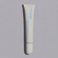 Tube of 'rhode' lip treatment on a gray background
