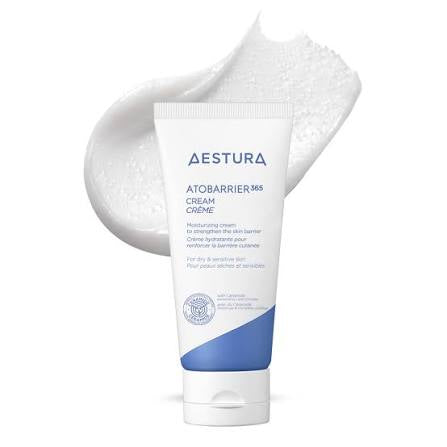 A tube of Aestura AtobARRIER M65 Cream Crème moisturizing cream shown against a white background with a textured smear of white cream behind it.