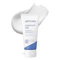 A tube of Aestura AtobARRIER M65 Cream Crème moisturizing cream shown against a white background with a textured smear of white cream behind it.