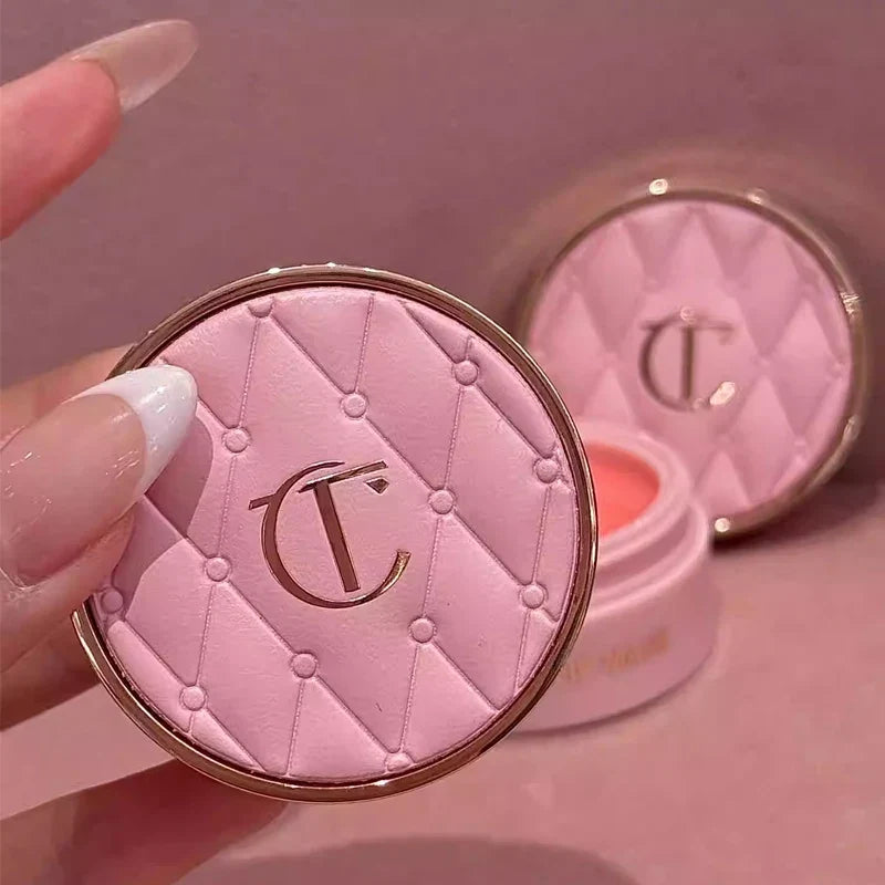 Pink makeup compact with a brand logo on a pink background