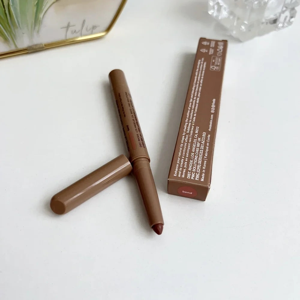 Brown makeup pencil with packaging on a white surface