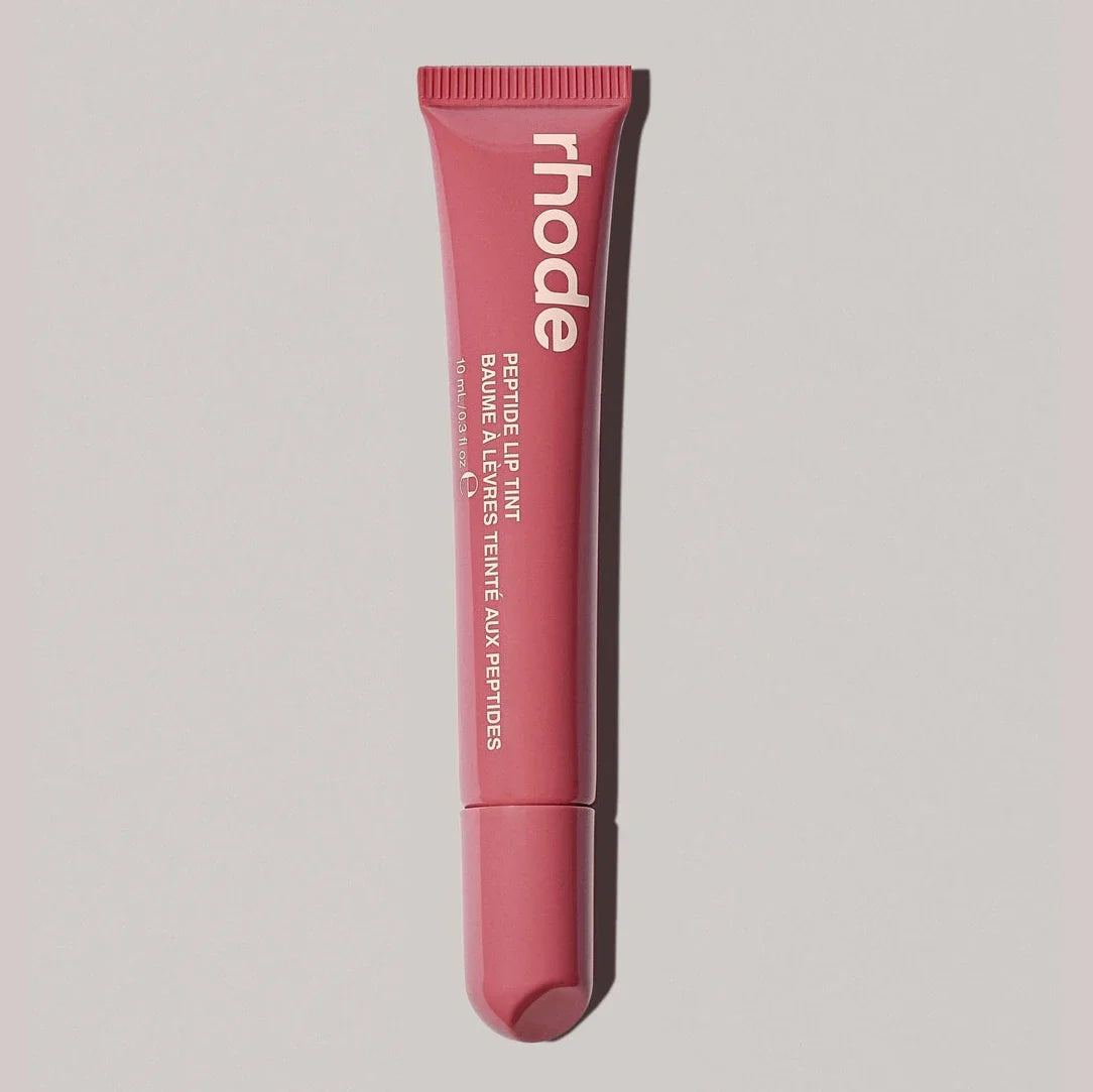 Pink lip balm tube with 'rhode' branding on a light gray background