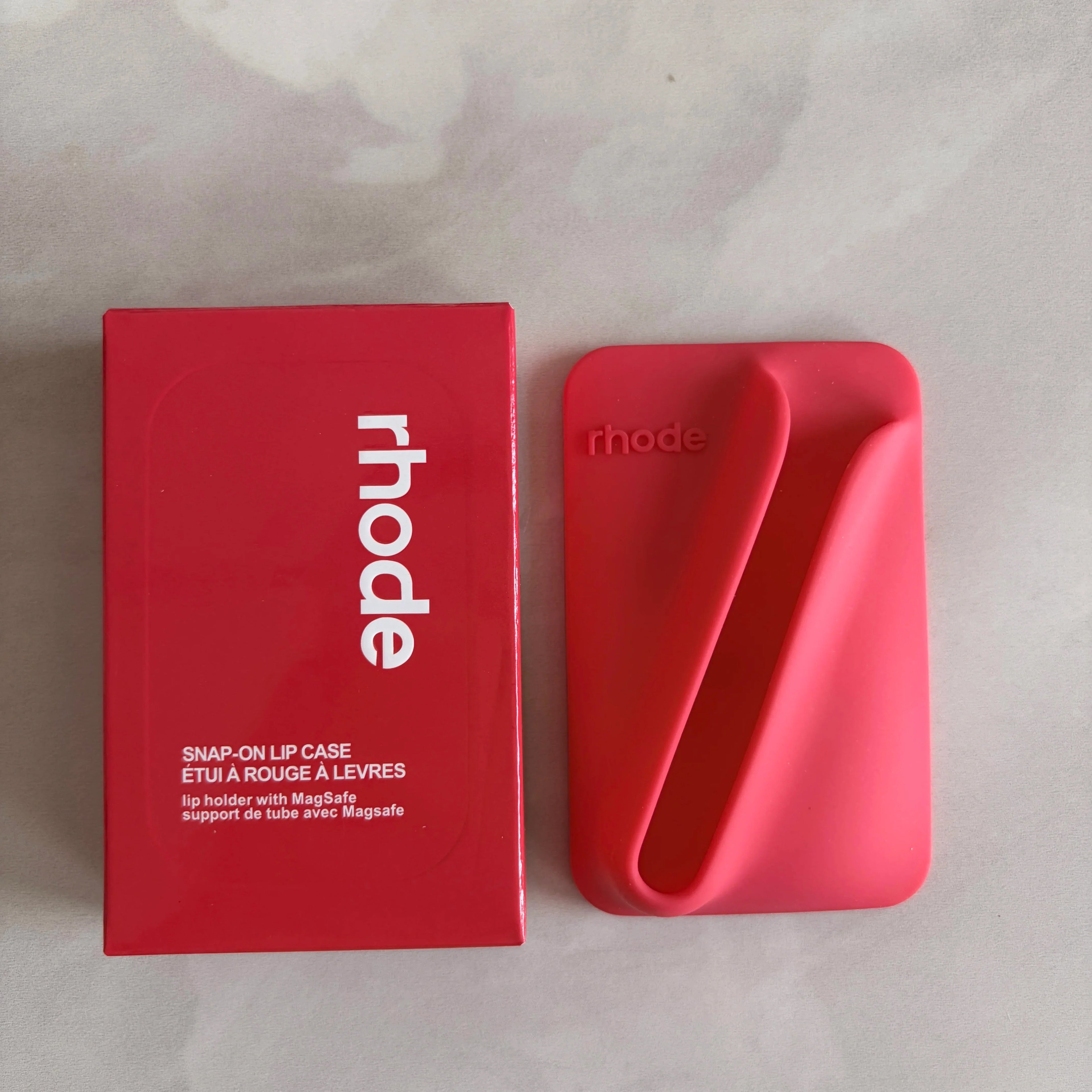 Red 'rhode' snap-on lip case on a light gray background